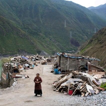 A woman stands next to the debris of demolished houses and her makeshift hut near Lianghekou in Sichuan province, the site of the latest huge dam to be built in China’s drive for greener sources of power. Photo: AFP