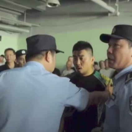 Police officers talk with Xu Xiaodong in Shanghai on Monday after calling time on his planned four-man team contest with tai chi master Ma Baoguo. Photo: Handout