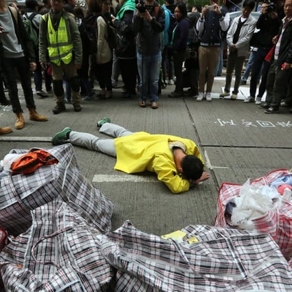 In the aftermath of Occupy, a man lies on the ground during the clearance operation in Causeway Bay.