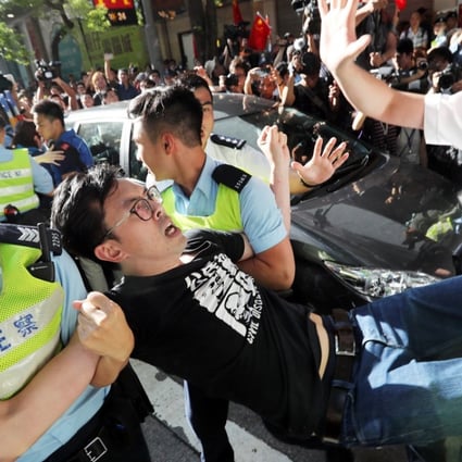 Police officers detain League of Social Demarcates chairman Avery Ng Man-yuen during a protest near the flag raising ceremony at Golden Bauhinia Square. Photo: Edward Wong