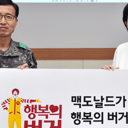 McDonald's Korea CEO Cho Ju-yeon, right, poses with Korea Army Training Center Commander Maj. Gen. Koo Jae-seo at the boot camp in Nonsan, South Chungcheong Province, Monday. The hamburger chain agreed to offer free burgers to recruits there. Photo: McDonald's Korea
