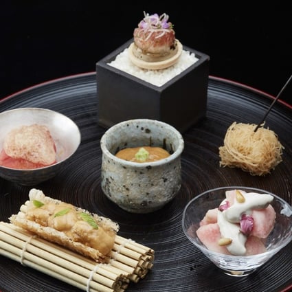 Tenku Ryugin's appetiser platter of sea urchin cracker, fruit tomato, cherry salmon crispy noodles, foie gras with figs, salted sea cucumber innards with seaweed, and peach and tofu paste.