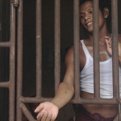 Kyaw Naing, a slave from Myanmar, talks to a security guard through the bars of a cell at the compound of a fishing company in Benjina, Indonesia, in 2014.Photo: AP
