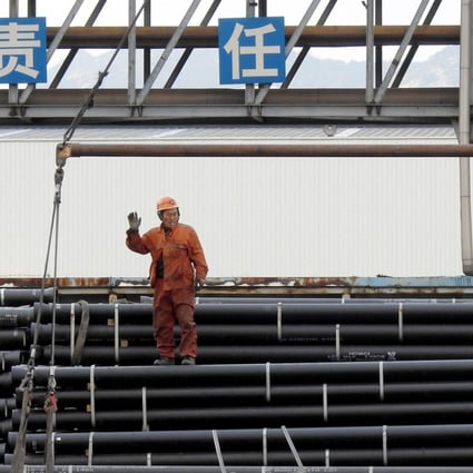 Chinese workers load steel tubes onto a truck at a logistics centre in Lianyungang in east China's Jiangsu province. Photo: AFP