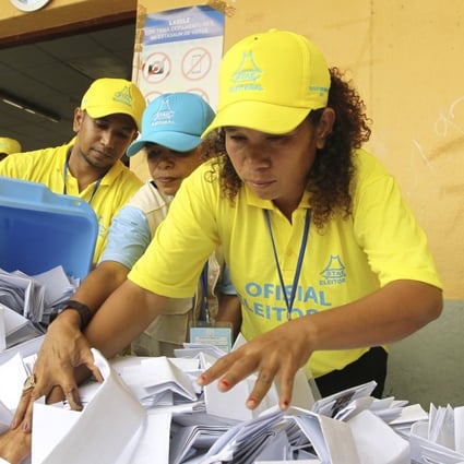 Electoral workers empty a ballot box as votes are counted during the parliamentary election in Dili, East Timor. Photo: AP