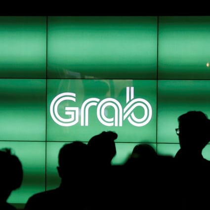 People wait for the start of ride-hailing company Grab's fifth anniversary news conference in Singapore. Photo: Reuters