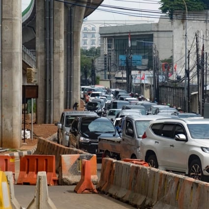 Vehicles pack a narrow road next to an under-construction flyover in Jakarta. Photo: AFP