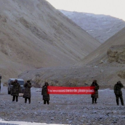 Chinese troops hold a banner which reads "You've crossed the border, please go back" in Ladakh, India. India has said it is ready to hold talks with China with both sides pulling back their forces to end a stand-off along a disputed territory high in the Himalayan mountains. Photo: Associated Press