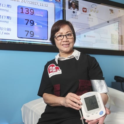 User Ho Yuk-ling demonstrates one of the devices at the show flat which can automatically upload blood pressure data. Photo: K. Y. Cheng