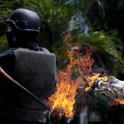 Opposition protesters clash with Bolivarian National Guard while blocking a street in during a protest against elections for the National Constituent Assembly in Barquisimeto, Venezuela, on Sunday. Photo: EPA