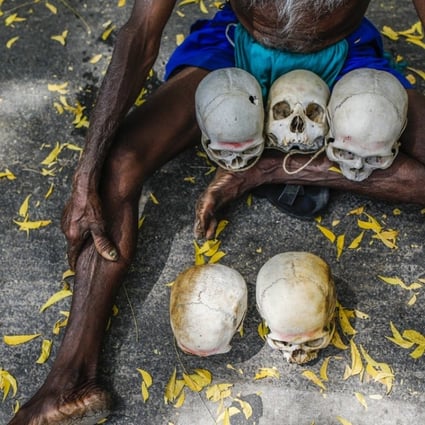 A farmer from the southern state of Tamil Nadu sits on the ground with the skulls of farmers who have committed suicide in their region. File photo: Bloomberg