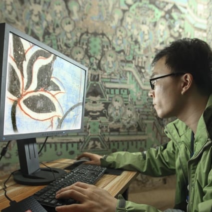 A staff member from the Dunhuang Research Academy performs digitalisation work in one of the Mogao caves. Photo: Dunhuang Research Academy