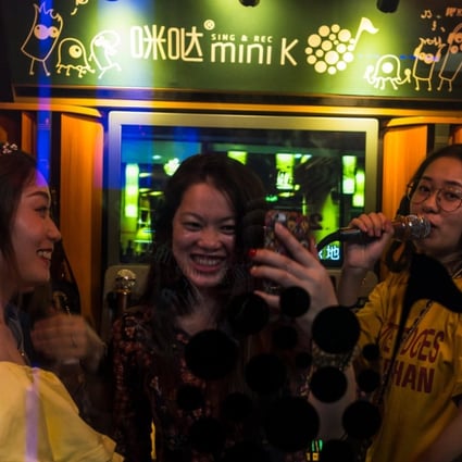 Three women enjoying a sing-song at a karaoke booth in Shenzhen. Photo: EPA