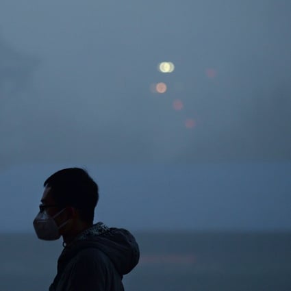A man wearing a mask in a park amid heavy air pollution in Beijing. The PBOC estimates that an annual investment of 2 to 4 trillion yuan will be required to address climate change issues. Photo: AFP