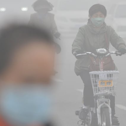 A woman wearing a mask rides in smog-shrouded Tianjin in northern China. Photo: Xinhua
