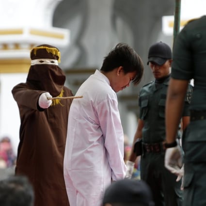 A man is caned for being in a same-sex relationship in Banda Aceh, Indonesia. Fears of such reprisals are keeping many gay men away from necessary health services in the region. Photo: EPA