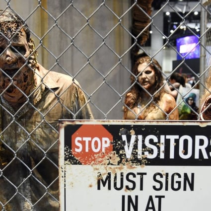 Zombie characters walk inside a cage at the "Walking Dead" exhibit on the convention show floor during Preview Night of the 2017 Comic-Con International show in July in San Diego. Photo: AP
