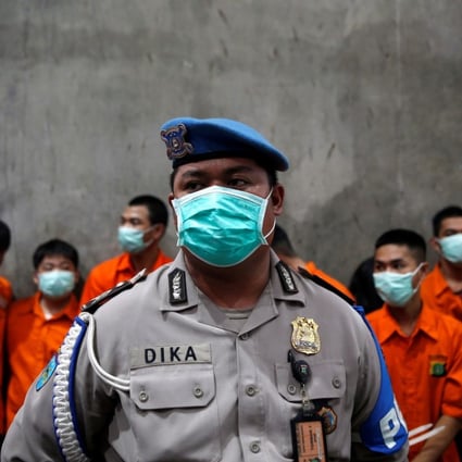 Drug suspects are seen waiting to watch the destruction of recently confiscated narcotics. Photo: Reuters