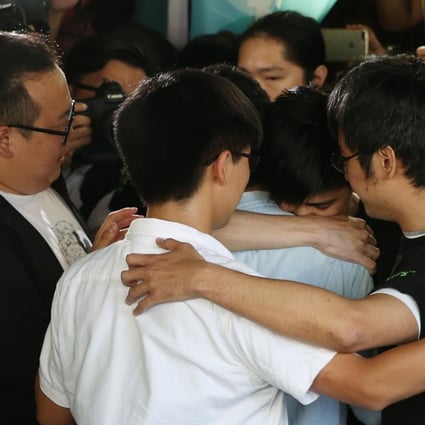 Joshua Wong, Nathan Law, Alex Chow and Lester Shum embrace outside the High Court. Photo: Sam Tsang