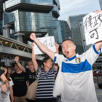 Supporters of student activists Joshua Wong, Nathan Law and Alex Chow hold up signs reading “Shame on the Department of Justice” (right) and “Freedom Stolen” as the three leave Hong Kong’s High Court in prison vans, on August 17. Photo: EPA