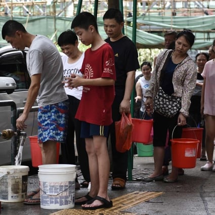 Residents queue up to collect water from a fire hydrant. Photo: AFP