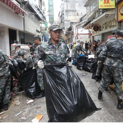 The Chinese Army helps Macau residents with the recovery effort after Typhoon Hato hit the city. Photo: Edward Wong