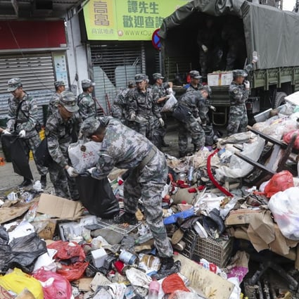 PLA soldiers clear the streets of debris in Macau. Photo: Edward Wong