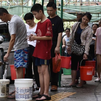 People queue up to collect water from a fire hydrant in Macau on August 24, a day after Typhoon Hato left a trail of destruction, with water supplies badly hit. Photo: AFP