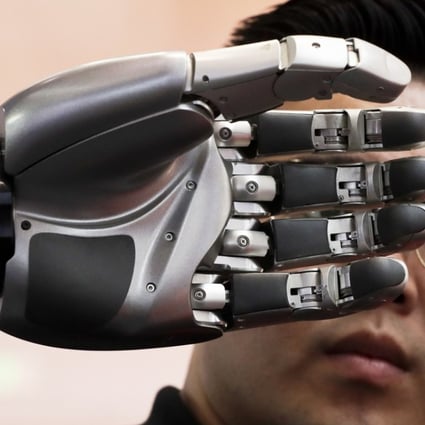 A visitor looks at a robotic hand on display at the World Robot Conference in Beijing on August 23. Policymakers must ensure they keep their focus on what it really means to be a smart city. Photo: AP