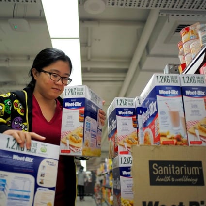Chinese daigou shopping agent Na Wang selects an Australian breakfast cereal product during a shopping trip for Chinese customers at an Australian supermarket in Sydney. Photo: Reuters