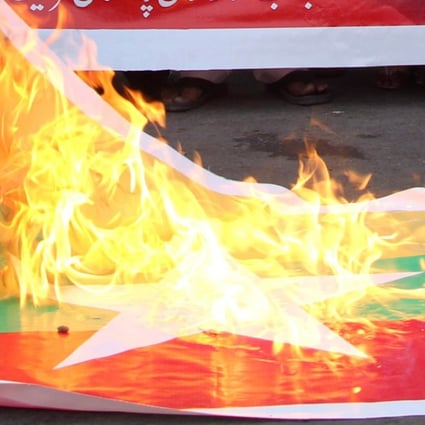 A Myanmar flag is torched in Pakistan during a protest in support of Rohingya Muslims. Photo: AFP