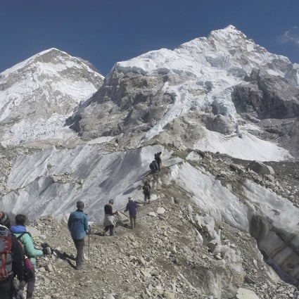 International trekkers pass through a glacier at the Mount Everest base camp, Nepal. Scientists say a third of the ice stored in Asia’s glaciers will be lost by the end of the century even if global warming stays below 1.5 degrees Celsius. Photo: AP