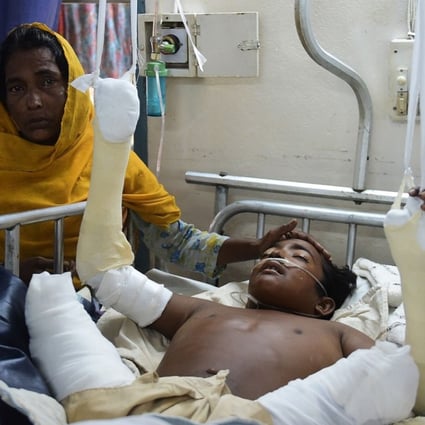 Rohingya Muslim refugee Rashida Begum stands next to her son Azizul Hoque, 15, as he is treated after being injured by a landmine while crossing from Myanmar to Bangladesh, at a hospital in Cox's Bazar. Photo: AFP