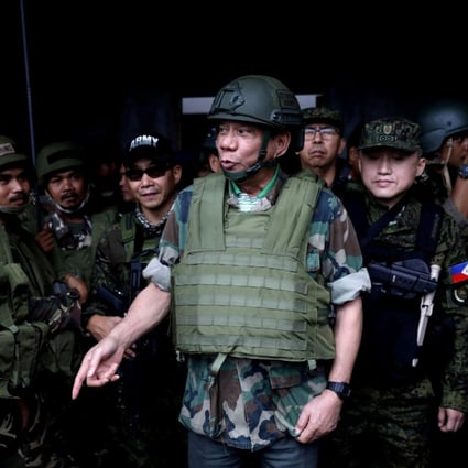 Philippine President Rodrigo Duterte wears a bulletproof vest and a helmet as he gives a pep talk to troops fighting the extremist Maute group in Marawi. Photo: Reuters