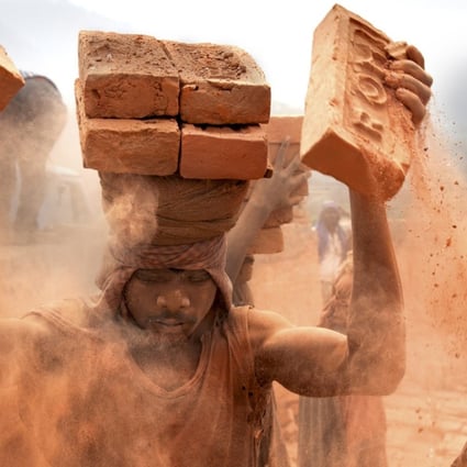 Stacking – Nepal: a brick kiln in Nepal. Each brick weighs about 2kg. The dust goes straight into the slaves’ lungs. Picture: Lisa Kristine