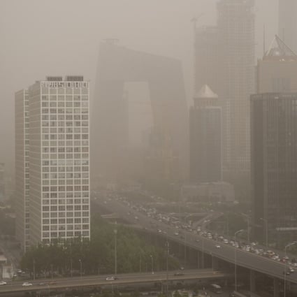 Beijing’s central business district is shrouded in a dust storm on May 4. China, the world's biggest auto market, is considering a ban on fossil fuel cars in a major boost to the production of electric vehicles as it seeks to ease pollution. Photo: AFP