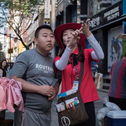 A South Korean guide directing tourists in the popular Myeongdong shopping area of Seoul. Less Chinese tourists are set to visit South Korea in the October Golden Week holiday period because of tensions between the two countries. Photo: AFP