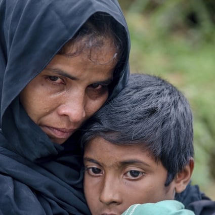 A Rohingya Muslim waits for help to transport her sick son to a nearby clinic in Taiy Khali, Bangladesh, on Wednesday. Photo: AP