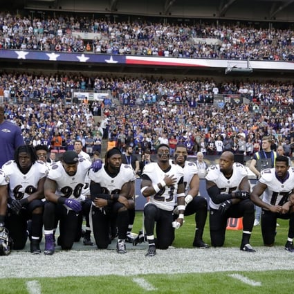 Baltimore Ravens players, and former player Ray Lewis, second from right, kneel during the playing of the US national anthem before an NFL football game against the Jacksonville Jaguars at Wembley Stadium in London, on Sunday. Photo: AP
