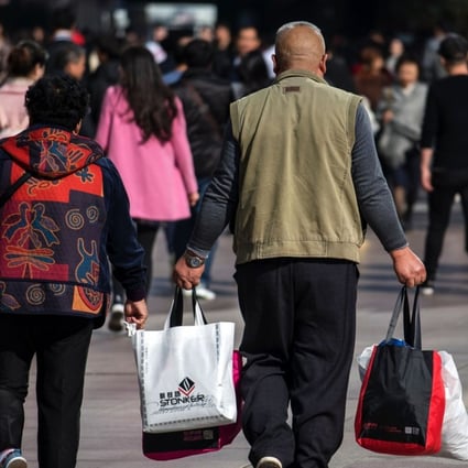 A couple carry bags along the main shopping street in Shanghai last November. More market rather than less is key to sustaining China’s economic growth in the long term. Photo: AFP