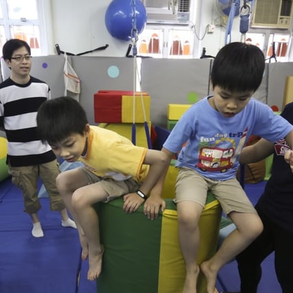 From left: Wu Kit-man and Yeung Kwok-wai with their twins Ho-kit (yellow T-shirt) and Ho-chun and instructor Lee Lai-yee at the Louis Program Training Centre in Yau Ma Tei. Photo: Jonathan Wong