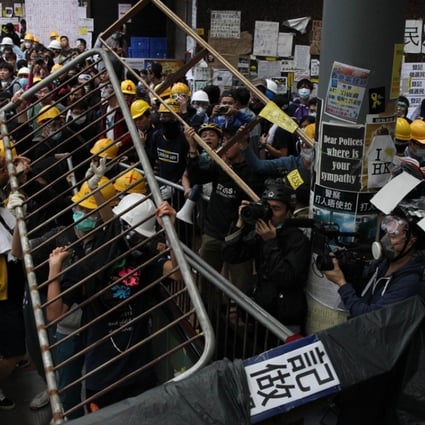 Pro-democracy protesters lift barricade reinforcements up onto an escalator near the government headquarters in Admiralty during the Occupy movement in 2014 as police and students clash. AFP PHOTO / DALE de la REY