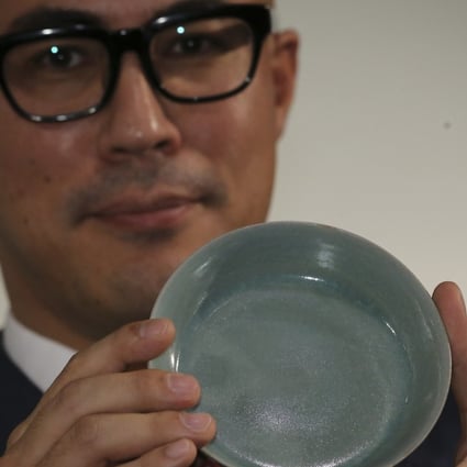 Nicolas Chow, deputy chairman of Sotheby's Asia, holds the Northern Song dynasty brush washer sold for HK$294.3 million, a new auction record for Chinese ceramics. Photo: Dickson Lee