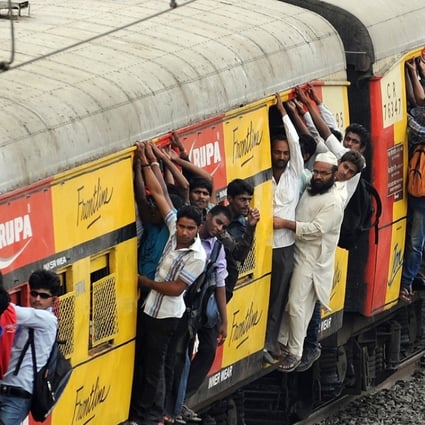 Commuters hang onto an overcrowded suburbun railway train in Mumbai. Photo: AFP