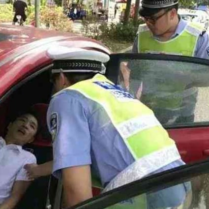 Traffic police assist a driver who fainted while he was stuck in traffic on the Humen Pearl River Bridge in Guangdong. Photo: Gmw.cn