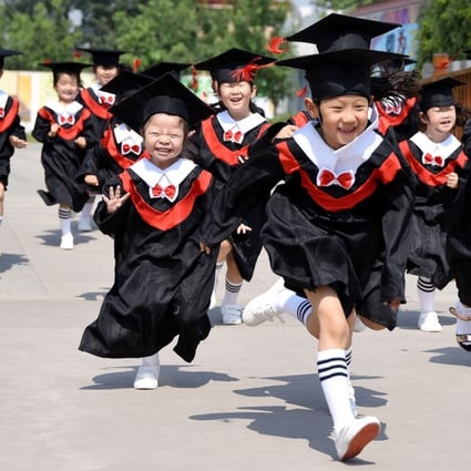 Children in gowns and mortarboards run with smiles during their kindergarten graduation ceremony in a kindergarten in Handan, Hebei province, China. Photo: REUTERS