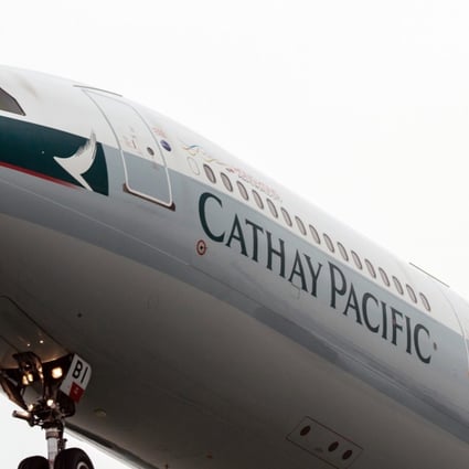 A Cathay Pacific aircraft flies near Hong Kong International Airport in Hong Kong. Photo: Bloomberg