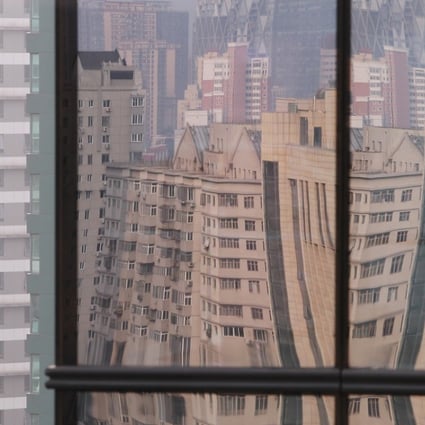 Buildings reflected in the glass wall of a high rise building in the Central Business District of Beijing. Photo: Simon Song
