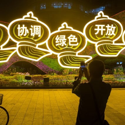 A man takes pictures of a display of Chinese characters representing the leadership's “Five Major Development Concepts” ahead of the 19th Party Congress in Beijing, on September 27. The characters read: “Innovation, Coordination, Green, Openness and Sharing”. Photo: Reuters