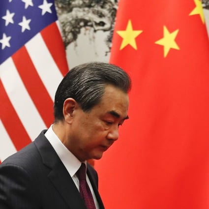 Chinese foreign minister Wang Yi walks past the US and Chinese national flags as he prepares to meet US Secretary of State Rex Tillerson at the Great Hall of the People in Beijing on September 30. Photo: EPA-EFE